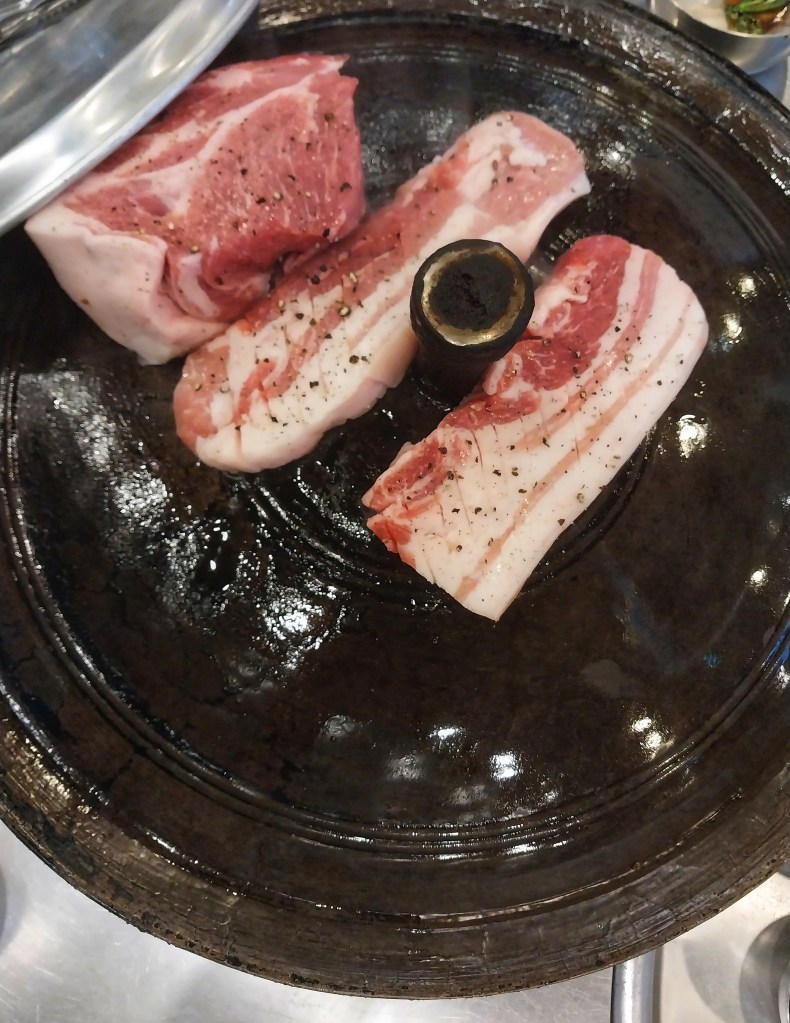 Samkyeopsal and Moksal cooking at a korean bbq